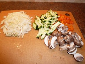Chopped vegetables for macaroni vegetable casserole - diced onion, sliced mushrooms, chopped pepper and diced zucchini