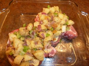 Porkchop in baking dish, stuffed and ready for the oven