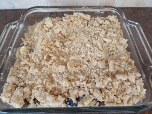 Layering dry mixture over berry mixture