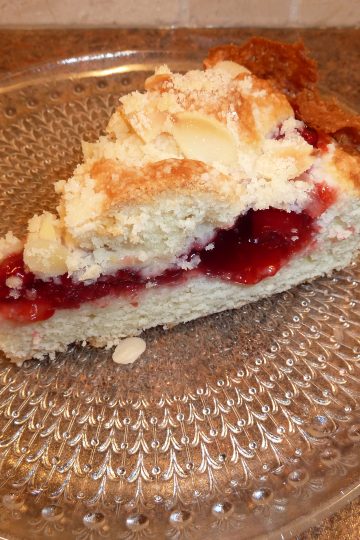 Slice of cherry coffee cake on glass plate