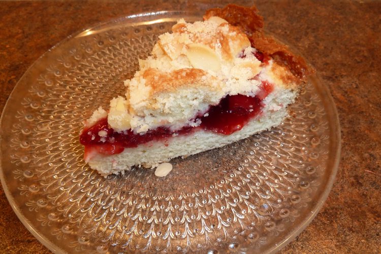 Slice of cherry coffee cake on glass plate