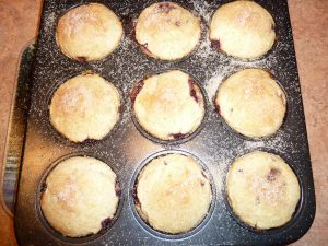 Baked doughnuts in muffin tin, unbaked but topped