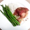 Baked stuffed salmon with asparagus and rice on a white plate