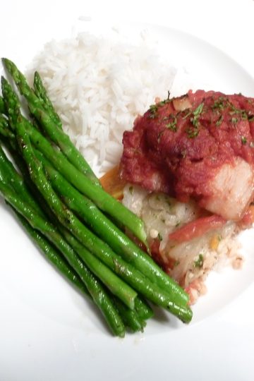 Baked stuffed salmon with asparagus and rice on a white plate