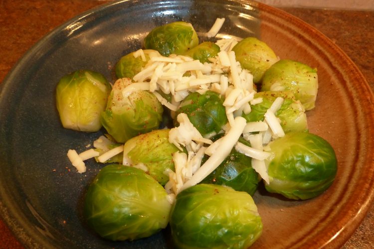 Cooked brussels sprouts topped with Asiago cheese