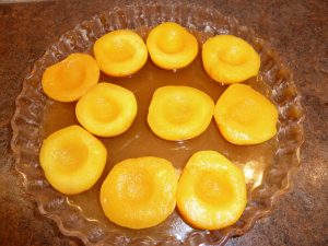 Peach halves in syrup at bottom of cake pan