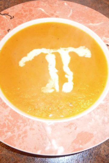 Sweet Potato and Pear Soup in a bowl with a Pi in creme fraiche