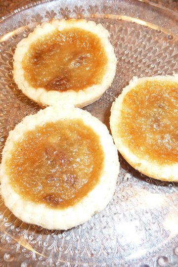 Three butter tarts on a plate.